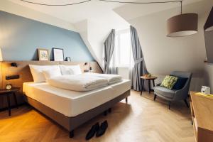 harry's home Berlin-Moabit hotel & apartments في برلين: غرفة نوم بها سرير وكرسي