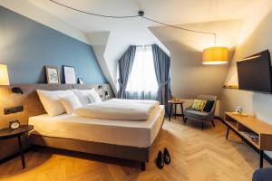 harry's home Berlin-Moabit hotel & apartments في برلين: غرفة نوم بها سرير ومكتب وتلفزيون