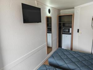 a small room with a bed and a flat screen tv at Premiere Classe Compiegne - Jaux in Jaux