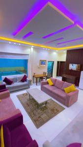 a living room with purple couches and a table at منتحع سيتي لاند 3 in Taif