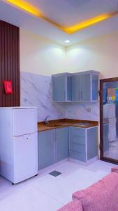 a kitchen with blue cabinets and a white refrigerator at منتحع سيتي لاند 3 in Taif