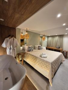 ein Schlafzimmer mit großem Bett und Badewanne in der Unterkunft Terra Bella Pousada in Morro de São Paulo