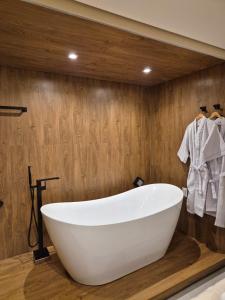 eine weiße Badewanne im Bad mit Holzwänden in der Unterkunft Terra Bella Pousada in Morro de São Paulo