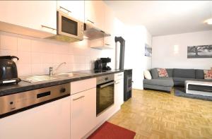 a kitchen with a sink and a couch in a room at Kitzsteinhorn Kaprun Panorama in Dürnberg