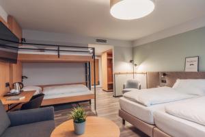 a bedroom with two bunk beds and a couch at harry's home Salzburg in Salzburg