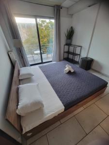 Nicole sharing apartments في أثينا: سرير كبير في غرفة مع نافذة كبيرة