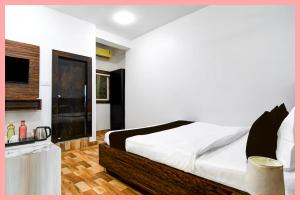 Un dormitorio con una cama grande y una cocina. en Hotel Velora Luxuary Near Railway Station, en Ujjain