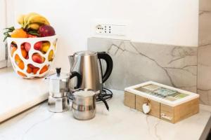 a kitchen counter with a coffee pot and a bowl of fruit at Casa Imperati in Agerola
