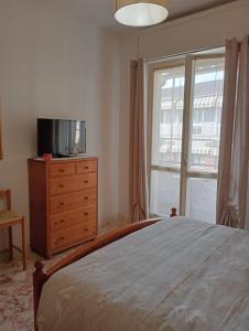 a bedroom with a bed and a tv on a dresser at Accommodation in the town center, on a private courtyard in CastellʼAlfero +17 photos