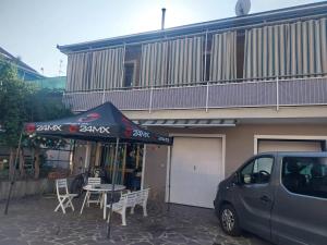 a car parked in front of a building with a tent at Accommodation in the town center, on a private courtyard in CastellʼAlfero