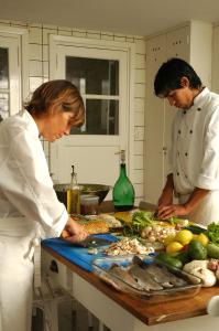 a couple of people in a kitchen preparing food at El Castillo de Mandl in La Cumbre