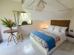 una camera da letto con un letto, un tavolo e una finestra di Pomelo Hostal a Dibulla