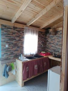 een keuken met een wastafel en een bakstenen muur bij The Corsair Cottage in Kalymnos