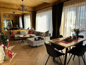 Sobiczkowy Dwór Apartament - Giewont Premium DeLuxe & SPA في كوشتيليسكا: غرفة معيشة مع أريكة وطاولة