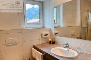 a bathroom with a sink and a mirror at Sporthotel Bergheim in Sölden +66 photos