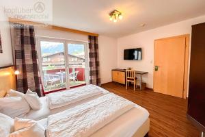 a hotel room with two beds and a large window at Sporthotel Bergheim in Sölden