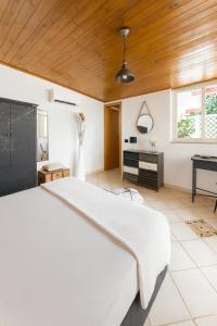 ein Schlafzimmer mit einem weißen Bett und einer Holzdecke in der Unterkunft La Casa del Viaggiatore in Milazzo