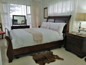 a bedroom with a large bed and a mirror at 83 Ocean View in Port Shepstone