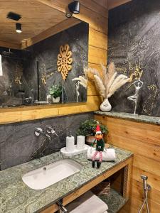 Sobiczkowy Dwór Apartament - Giewont Premium DeLuxe & SPA في كوشتيليسكا: حمام مع دمية قزم تجلس على الحوض