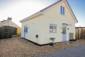 ein weißes Haus mit einem Kieshof in der Unterkunft Cosy Retreat in Pool