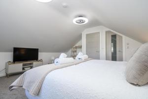 ein Schlafzimmer mit einem großen weißen Bett mit Handtüchern darauf in der Unterkunft Cosy Retreat in Pool