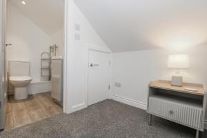 ein Badezimmer mit Toilette, Schreibtisch und Lampe in der Unterkunft Cosy Retreat in Pool + 33 Fotos