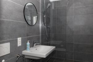 ein Badezimmer mit Waschbecken und Spiegel in der Unterkunft BM Rooms Innenstadt - Große Moderne City Apartments mit eigenem Bad im Herzen der Stadt in Bamberg