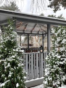 a pavilion with a white fence in the snow at Piejūras māja skandināvu stilā! Seaside scandi house! in Lapmežciems