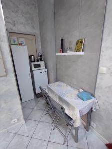 a small kitchen with a table and a refrigerator at Chambres d'hôtes - Les Orchidées in Perpignan