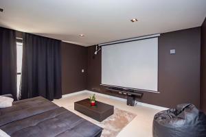 - un salon avec un canapé et un écran de projection dans l'établissement Edificio MUV Yogha, à Curitiba