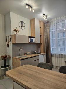 a kitchen with a sink and a table with chairs at Avinion 2 Апартаменты у моря in Odesa