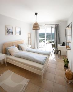 Ένα ή περισσότερα κρεβάτια σε δωμάτιο στο Arrifana Hideaway - Beautiful Seaview Apartment