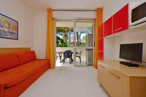 a living room with a couch and a television at Apartments in Lignano 21597 in Lignano Sabbiadoro