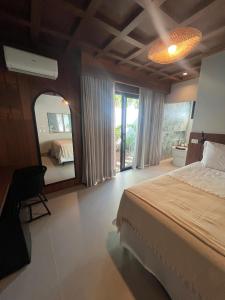 a bedroom with a bed and a large mirror at Pousada Cancun Boutique in Guarujá +74 photos