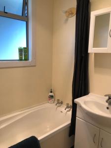 a bathroom with a bath tub and a sink at Te Anau Holiday House in Te Anau