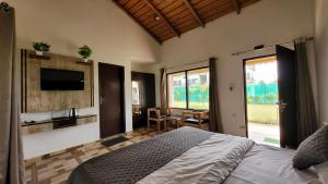 a bedroom with a bed and a sink and a television at Corbett Mid Forest House By Havensia Stays in Rāmnagar