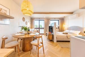 a living room with a dining room table and a bedroom at Wino&Grono Nałęczów in Nałęczów