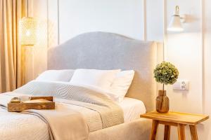 a bedroom with a white bed with a wooden table at Wino&Grono Nałęczów in Nałęczów