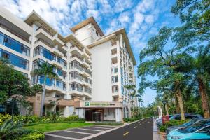 an apartment building with a car parked in front of it at Holiday Inn Express Haikou West Coast by IHG in Haikou