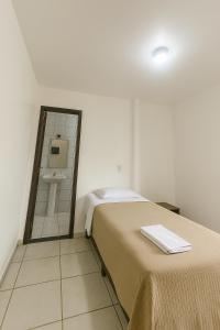 a bedroom with a bed and a sink and a mirror at Hotel Menegatti in Pato Branco +2 photos