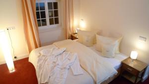 a white bed with white sheets and pillows in a room at Villa Andante Apartmenthotel in Kassel +5 photos