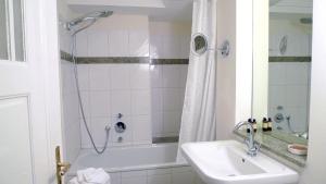 a bathroom with a tub and a sink and a shower at Villa Andante Apartmenthotel in Kassel
