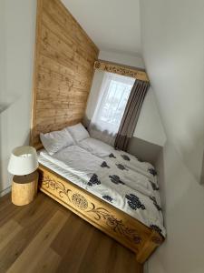 GÓRALSKIE NOWE APARTAMENTY BIAŁKA - Skibus, Sauny, Bania, Sale zabaw - w cenie في بيالكا تاترزانسكا: سرير صغير في غرفة بها نافذة