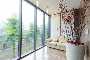 een woonkamer met een bank en grote ramen bij Hotel Jozef in Idrija