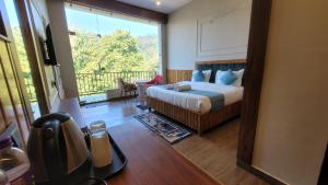 a bedroom with a bed and a balcony at Corbett Mid Forest House By Havensia Stays in Rāmnagar