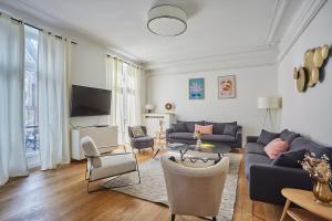 a living room with a blue couch and chairs at Apartment Center of Paris Montmartre by Studio prestige in Paris