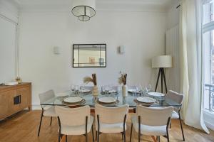 a dining room with a glass table and chairs at Apartment Center of Paris Montmartre by Studio prestige in Paris