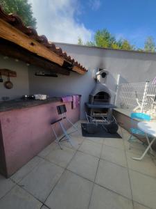 Lou Visetto à Vallon-Pont-d'Arc في فالون بون دارك: فناء مع فرن بيتزا وطاولة وكراسي