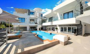 eine Außenansicht eines Hauses mit Swimmingpool in der Unterkunft Pnoe Beachside Living in Georgioupoli