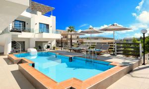 ein Swimmingpool vor einem Haus in der Unterkunft Pnoe Beachside Living in Georgioupoli